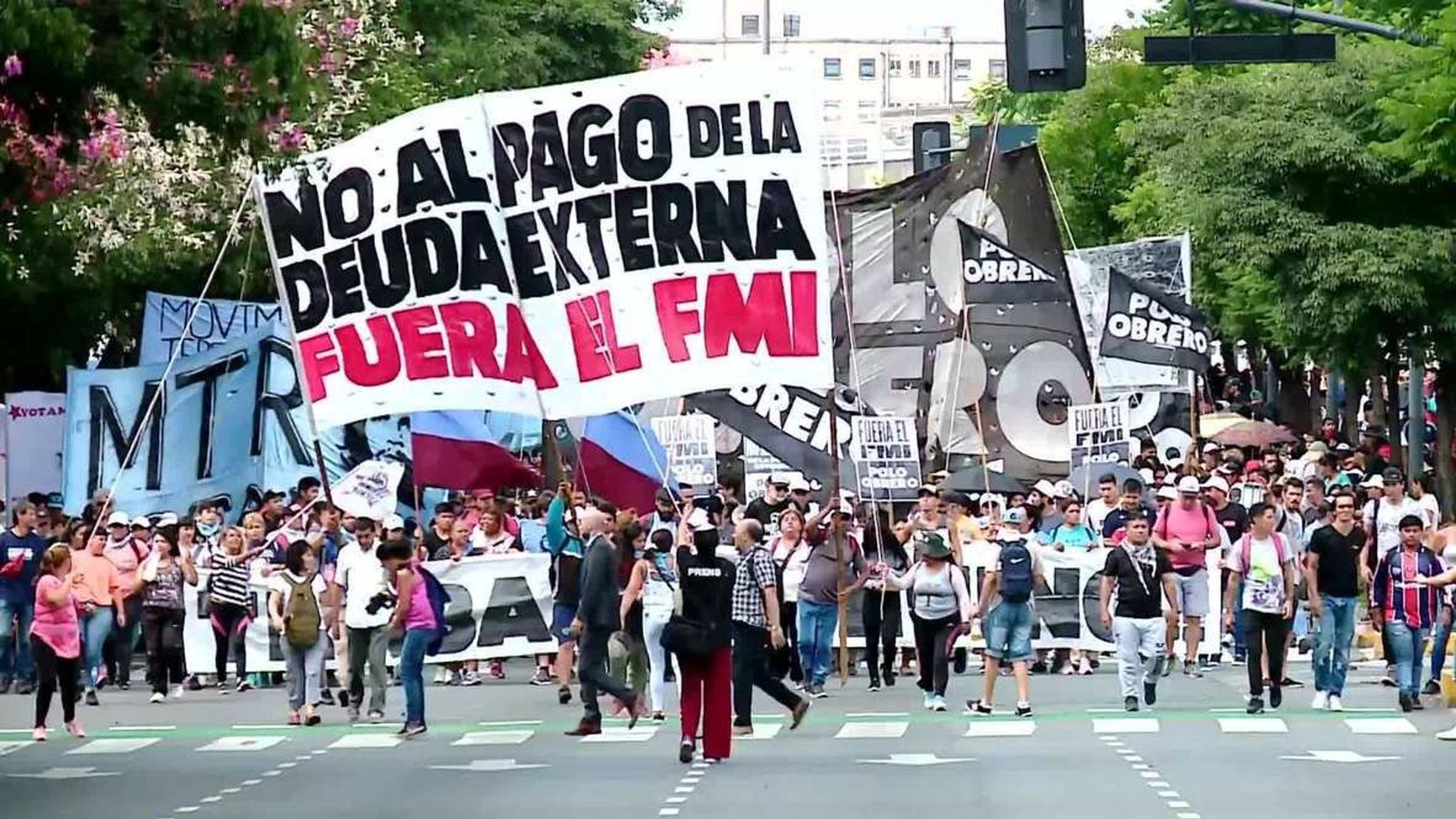 Protesters carrying signs “No to IMF!”, “IMF get out!”, and “IMF never again”